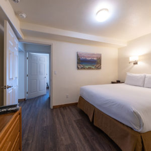 Two bedroom mountain condo bedroom with wood panel walls