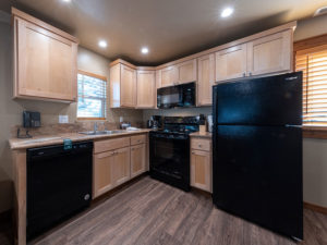 Two bedroom condo Mountain kitchen with black appliances including diswasher, stove, microwave and refrigerator