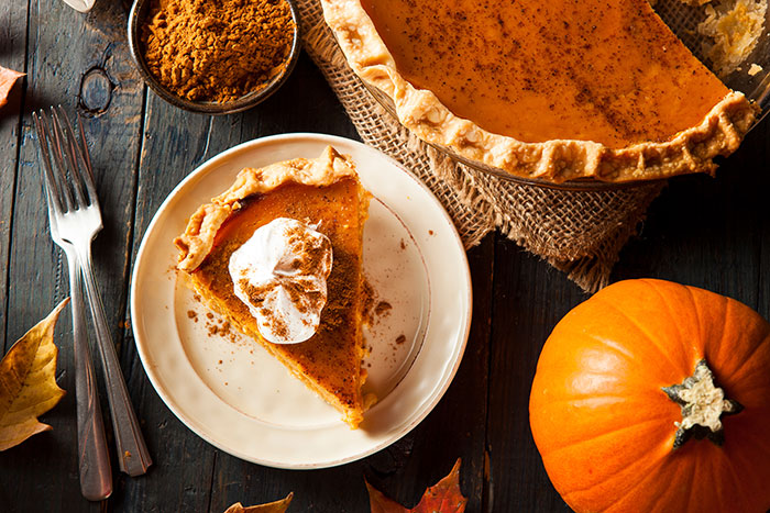 pumpkin pie with slice of pie topped with whipped cream