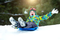 boy sledding happily