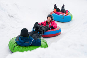 kids snow tubing downhill